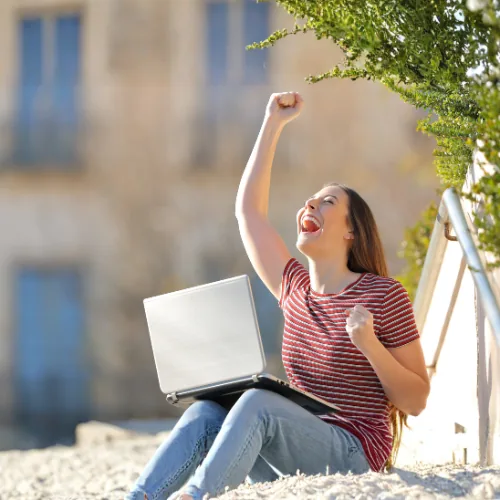 Candidate celebrating exam prep success at her laptop